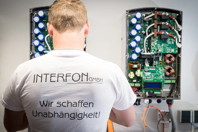 Ein Arbeiter der Interfon GmbH beim Einrichten eines Wechselrichters