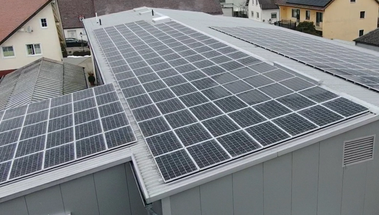 Eine fertige Photovoltaik-Anlage auf einer Fabrikhalle
